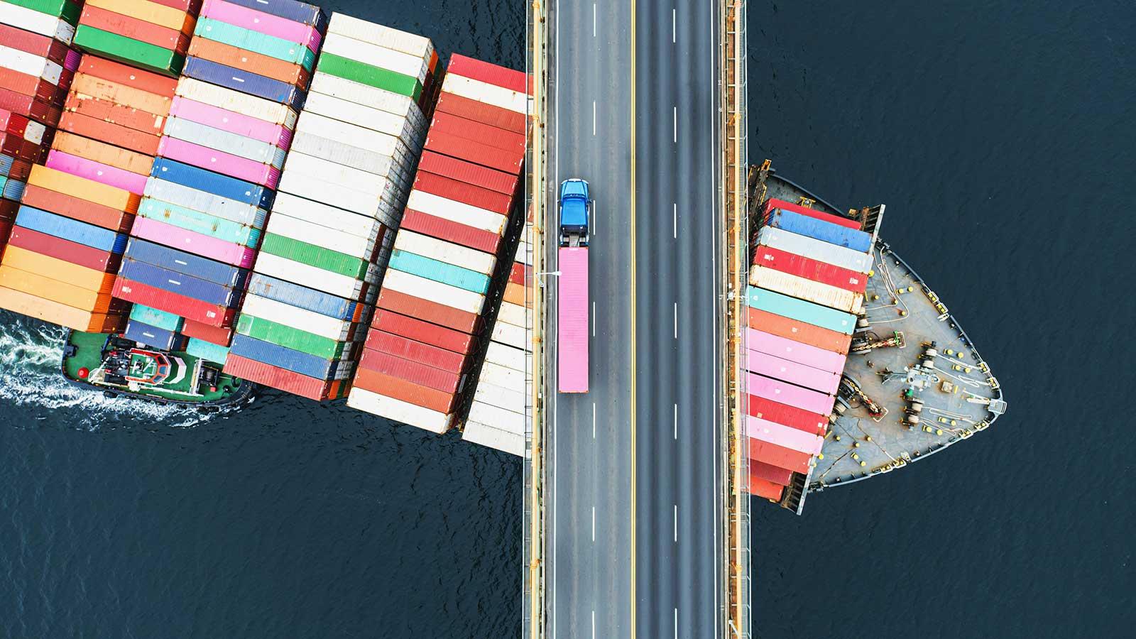 container ship passing under a bridge representing global supply chain